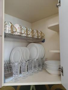eine Küche mit Tellern und Gläsern auf einem Regal in der Unterkunft ВИП КВАРТИРЫ in Kökschetau