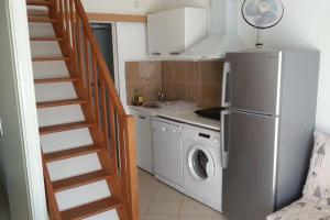 eine Küche mit einem Kühlschrank und einer Waschmaschine in der Unterkunft Villa vacances N°23 à 100 mètres de la plage in Saint-Cyprien