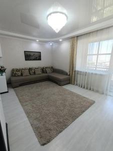 ein Wohnzimmer mit einem Sofa und einem großen Teppich in der Unterkunft ВИП КВАРТИРЫ in Kökschetau