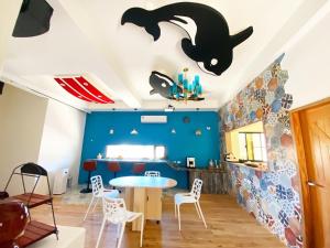 una sala da pranzo con tavolo e una mazza sul soffitto di 澎湖卡米諾民宿ll住宿接駁ll貓店長 a Magong