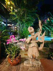 清邁的住宿－清邁恆考度假酒店，花朵花园中一个女孩的雕像