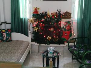 uma árvore de Natal numa sala de estar com uma mesa em SandyKosta em Kiáton