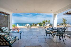 um pátio com uma mesa e cadeiras e o oceano em Lalaria Ocean Villa Suite 6 em Ballito