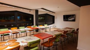 a room with tables and chairs and a large window at HYP'Hotel in Saint-Marcellin