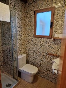 a bathroom with a toilet and a window at Airam Home Patio Centro in Almansa