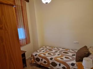 a small bedroom with a bed and a window at Airam Home Patio Centro in Almansa