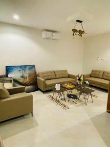 Sala de estar con 2 sofás y mesa en منتجع شرفا السياحي البيئي en Hail
