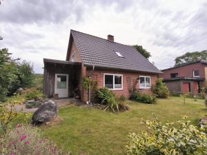 una pequeña casa de ladrillo con patio en Ferienzimmer Neuhaus, en Sieverstedt