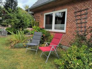 un grupo de tres sillas sentadas fuera de una casa en Ferienzimmer Neuhaus, en Sieverstedt