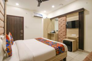 um quarto com uma cama e uma televisão de ecrã plano em FabHotel Spring em Amritsar