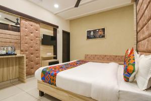 um quarto com uma cama grande e uma televisão em FabHotel Spring em Amritsar