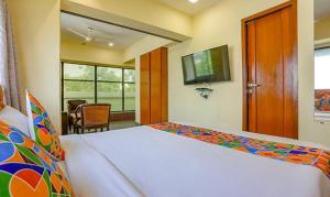 a bedroom with a bed and a television in a room at FabExpress Jayshree in Mumbai