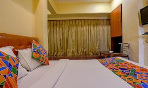 a bedroom with a large bed and a window at FabExpress Jayshree in Mumbai
