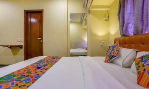 a bedroom with a large bed with a colorful blanket on it at FabExpress Jayshree in Mumbai