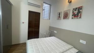 een slaapkamer met een wit bed en een raam bij Home Tales 275 by Tipiverse in Bangalore