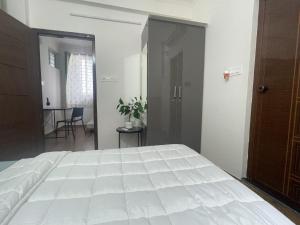 een slaapkamer met een groot wit bed en een tafel bij Home Tales 275 by Tipiverse in Bangalore