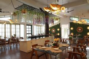 um restaurante com mesas e cadeiras num quarto em BLIZZ HOTELS RESORTS em Paliā Kalān