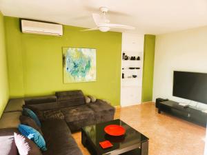 sala de estar con sofá y TV de pantalla plana en ÁTICO ZONA VENEZIOLA, LA MANGA en La Manga del Mar Menor