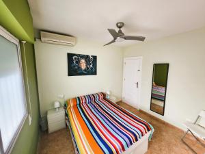 1 dormitorio con 1 cama y ventilador de techo en ÁTICO ZONA VENEZIOLA, LA MANGA en La Manga del Mar Menor