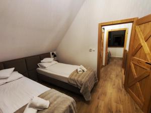 a small room with two beds and a door at Przystanek Gorce in Nowy Targ