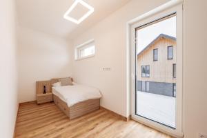 1 dormitorio con cama y ventana grande en Resort Malé Lipno en Černá v Pošumaví