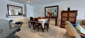 a kitchen and dining room with a table and chairs at Santorini, Margate in Margate