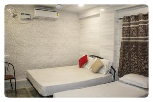 a bedroom with two beds and a air conditioner at Paradise Guest House in Chennai