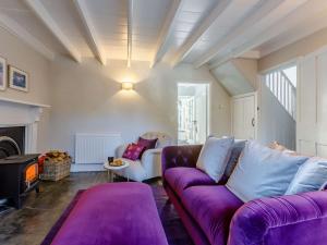 a living room with a purple couch and a fireplace at 2 Bed in Launceston 84660 in Tresmeer