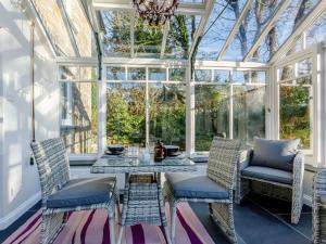 a conservatory with a table and chairs and a chandelier at 2 Bed in Launceston 84660 in Tresmeer