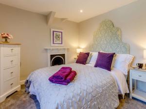 a bedroom with a large bed with purple pillows at 2 Bed in Launceston 84660 in Tresmeer