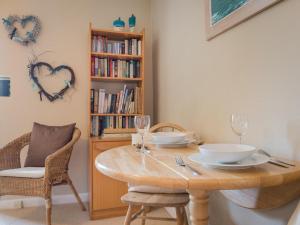 een eetkamer met een tafel en stoelen en een boekenplank bij 1 Bed in Matterdale SZ222 in Watermillock