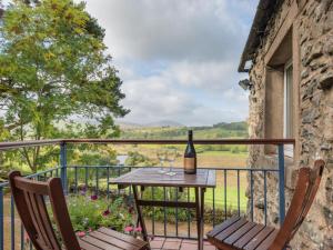 a table with a bottle of wine and two chairs on a balcony at 1 Bed in Matterdale SZ222 in Watermillock