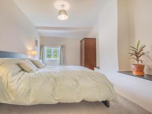 um quarto branco com uma cama grande e uma janela em 3 Bed in Duddon Valley SZ107 em Eskdale
