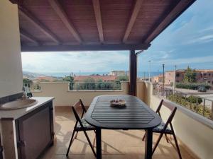 een tafel en stoelen op een balkon met uitzicht bij Attico Lu Bagnu panoramico in Castelsardo