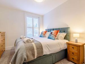 1 dormitorio con 1 cama con cabecero azul y ventana en 5 Bed in Matlock Bath 85188, en Matlock Bank