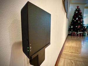 una televisione montata su un muro con un albero di Natale di Moderna habitación en el corazón de Alicante ad Alicante