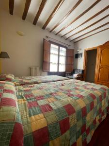 a bedroom with a large bed with a colorful quilt at Posada Santa Rita in Enciso