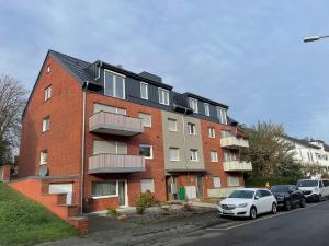 ein rotes Backsteingebäude mit davor geparkten Autos in der Unterkunft Apartment Lori in Mönchengladbach