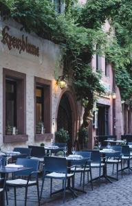 eine Gruppe von Tischen und Stühlen vor einem Restaurant in der Unterkunft Kreuzblume Hotel & Weinstube in Freiburg im Breisgau