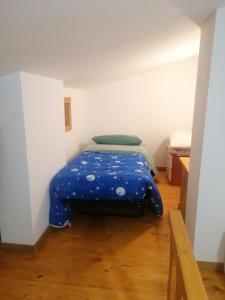 una camera con un letto con una coperta blu sopra di Casa Vacanza Molise a Castelpetroso