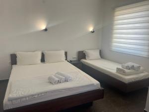 Dos camas en una habitación con toallas. en Nego apartmani en Kuršumlija