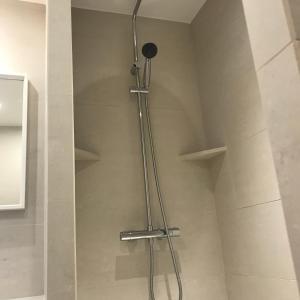 een douche met een douchekop in de badkamer bij AparisAppart in Pantin