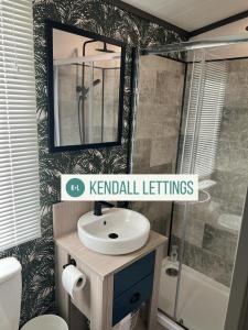 a bathroom with a sink and a mirror at Sea View Lodge in Selsey