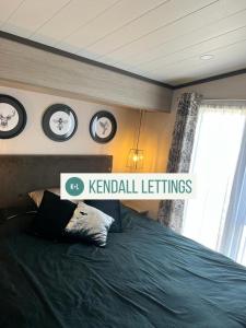 a bedroom with a bed with clocks on the wall at Sea View Lodge in Selsey