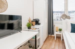 een witte woonkamer met een tv en een bank bij Kurzzeitglück 24h Self Check-In E02 in Essen