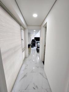 a hallway with white walls and marble floors at HANI Haus in Jeju