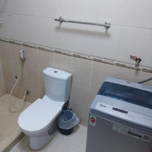 a bathroom with a toilet and a machine in it at العين الهيلي مصباح بيت14 in Al Ain