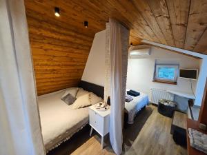 1 dormitorio con 2 camas y techo de madera en Kuća za odmor Šumska vila, en Duga Resa