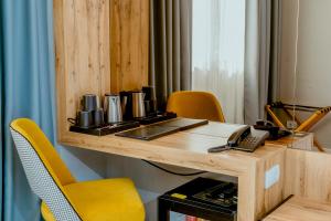 een houten tafel met een telefoon en stoelen bij Nobel Gallery Hotel in Belgrado