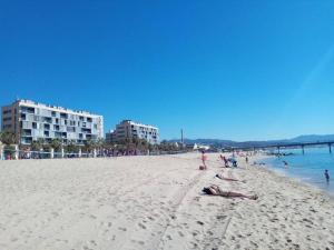 un gruppo di persone sdraiate sulla spiaggia di Apartamento PB 30min Sagrada Familia, 10 min playa a Badalona